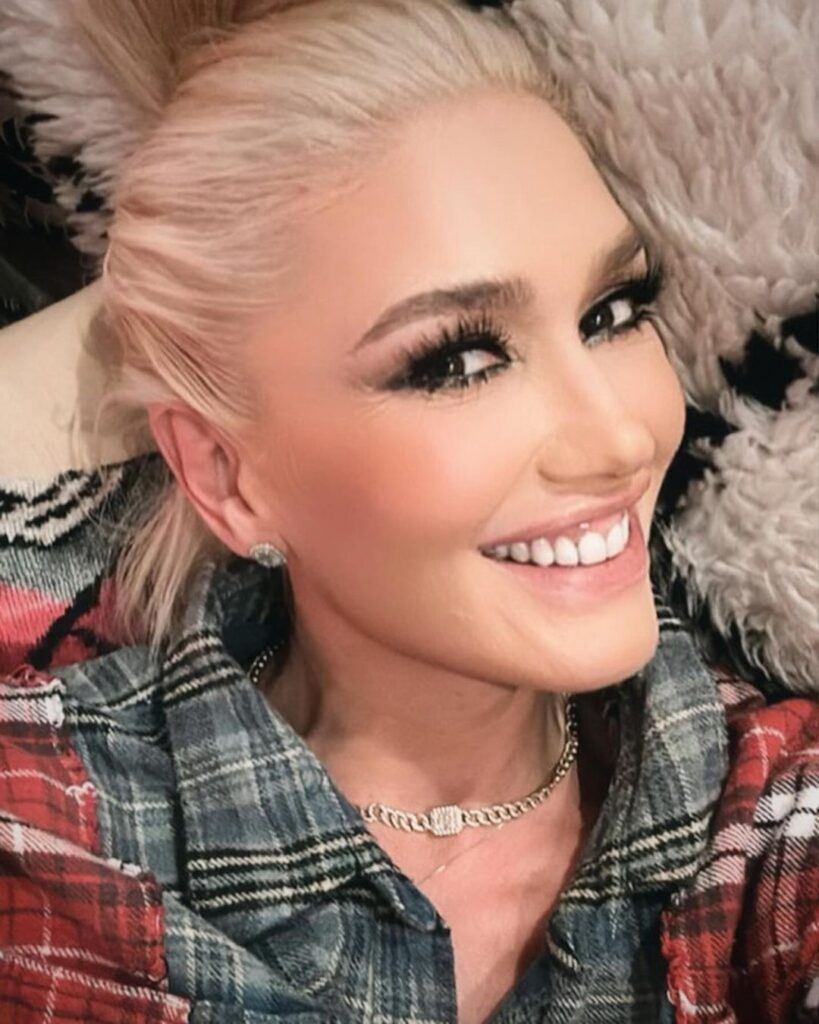 Gwen Stefani smiling with check shirt.